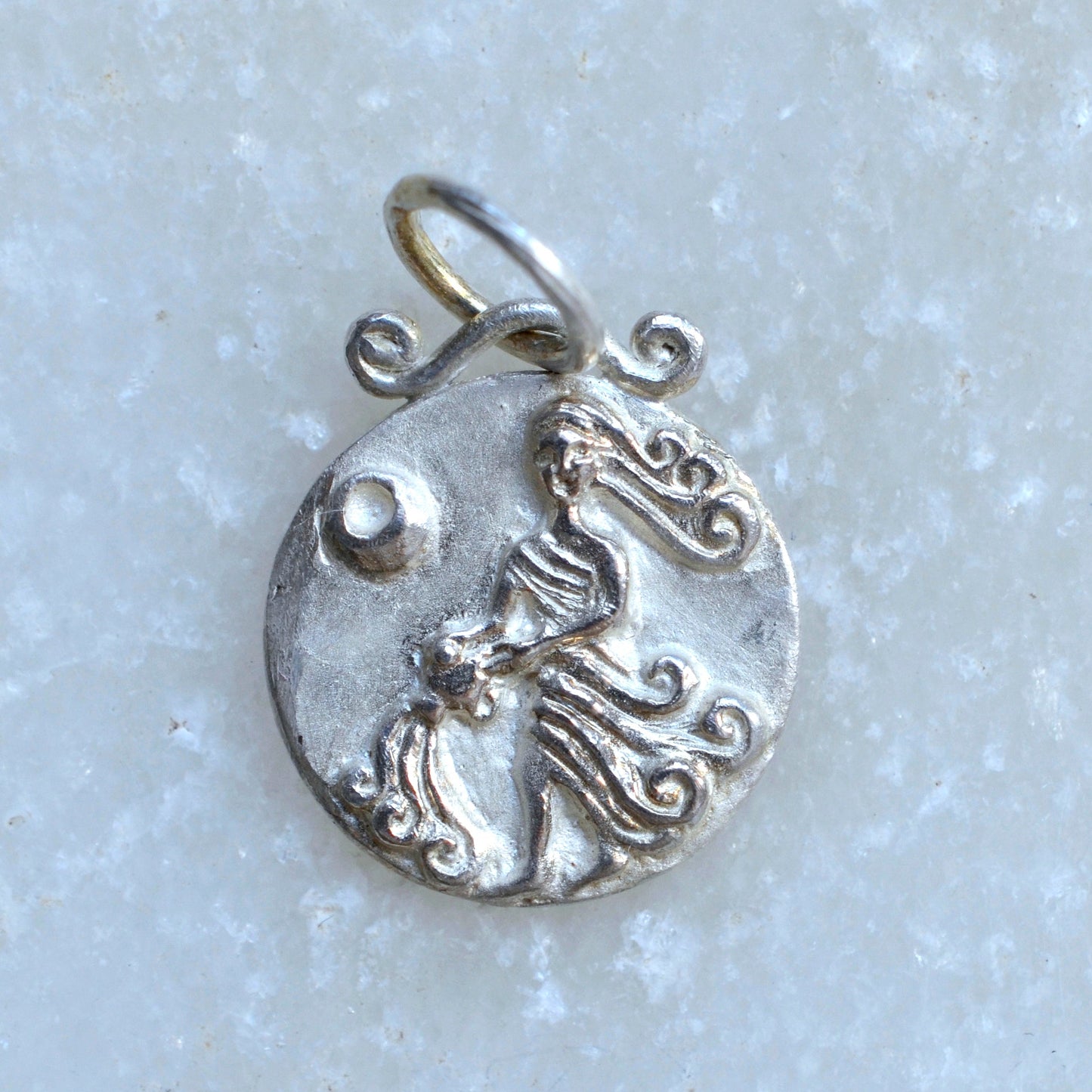 Aquarius zodiac pendant in silver on marble