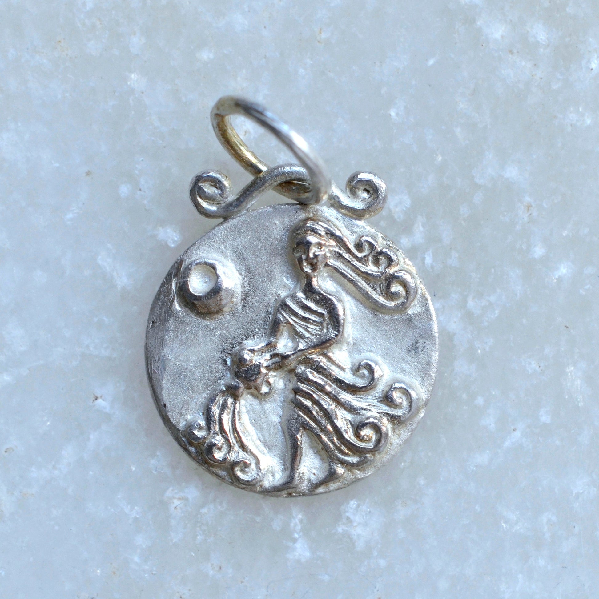 Aquarius zodiac pendant in silver on marble