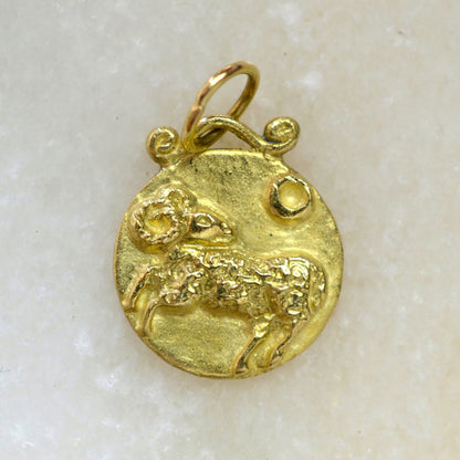 Aries zodiac pendant in 18 karat gold on marble