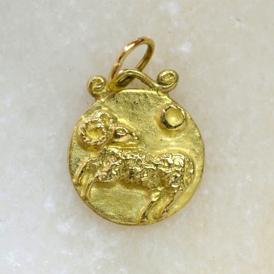 Aries zodiac pendant in 18 karat gold on marble