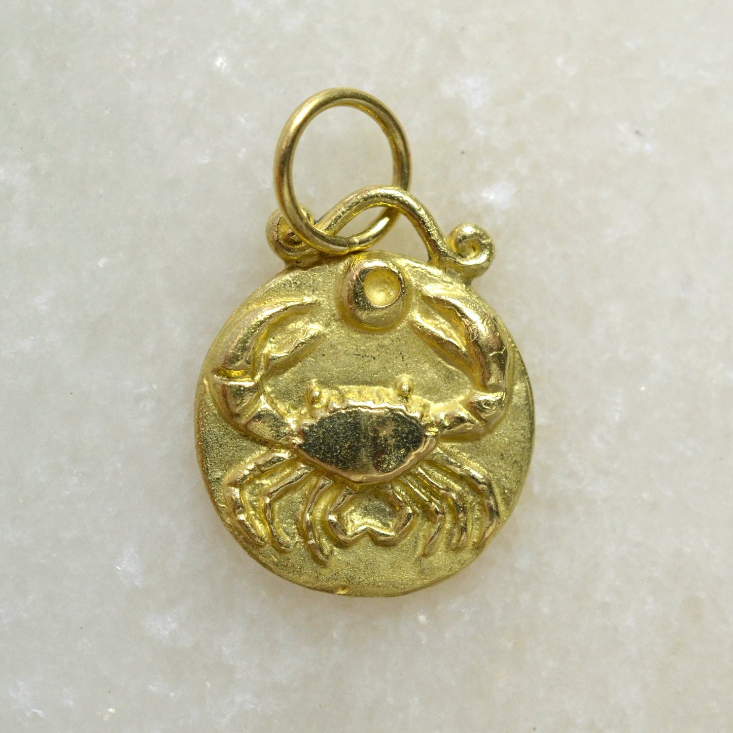 Cancer zodiac pendant in 18 karat gold on marble