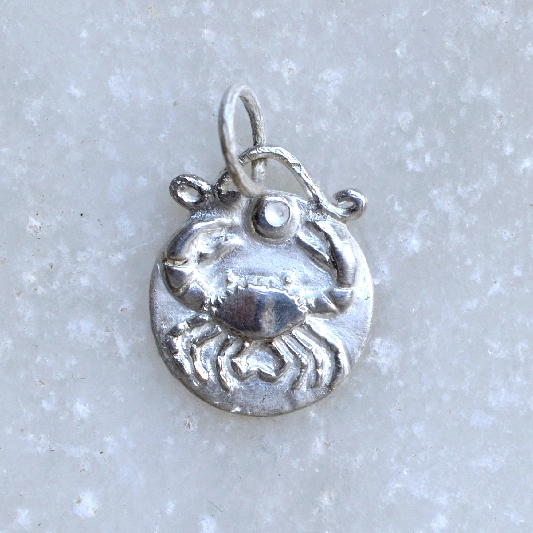 Cancer zodiac pendant in sterlin silver on marble