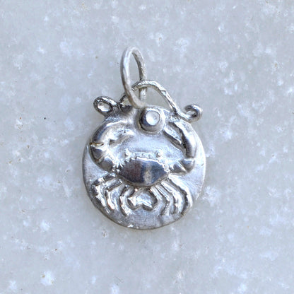 Cancer zodiac pendant in sterlin silver on marble