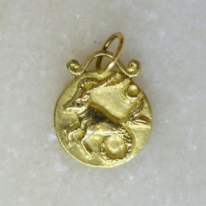 Capricorn zodiac pendant in 18 karat gold on marble