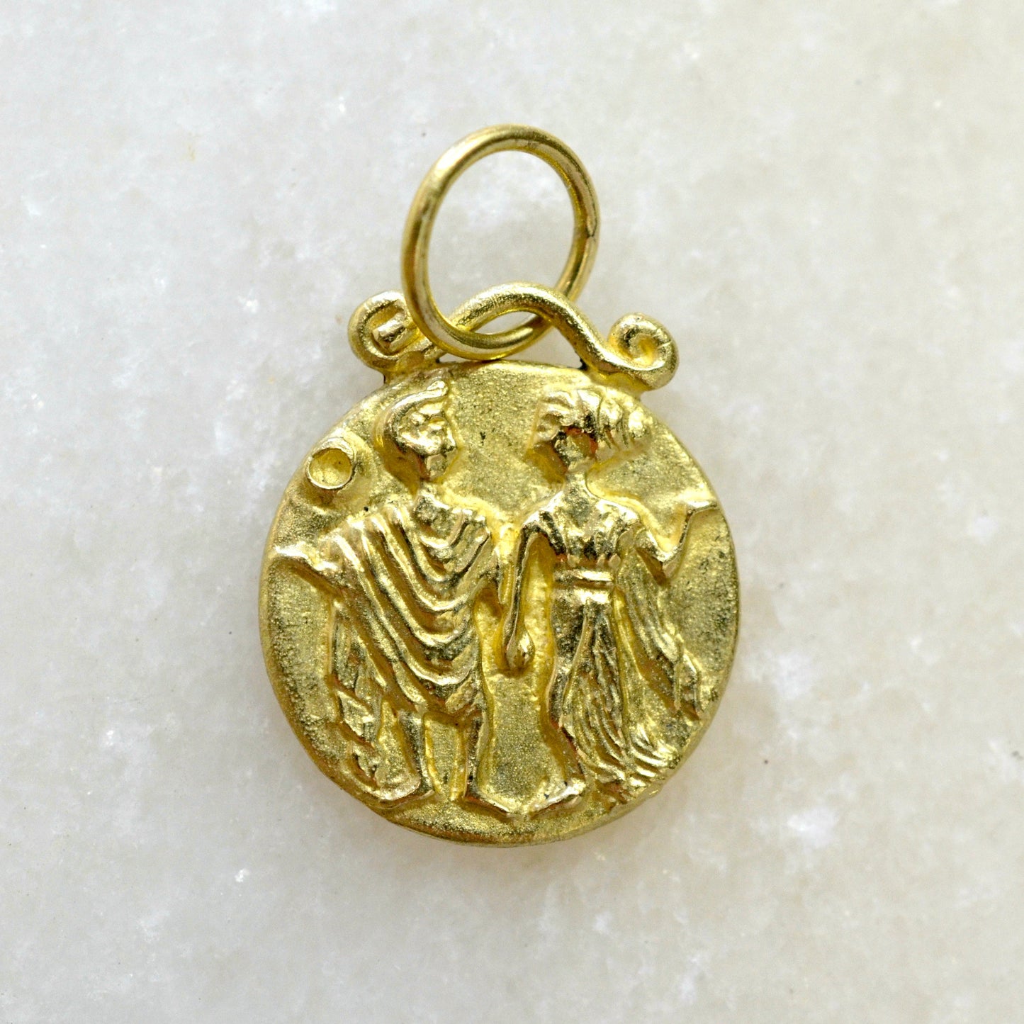 Gemini zodiac pendant in 18 karat gold on marble