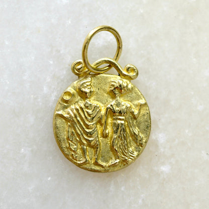 Gemini zodiac pendant in 18 karat gold on marble