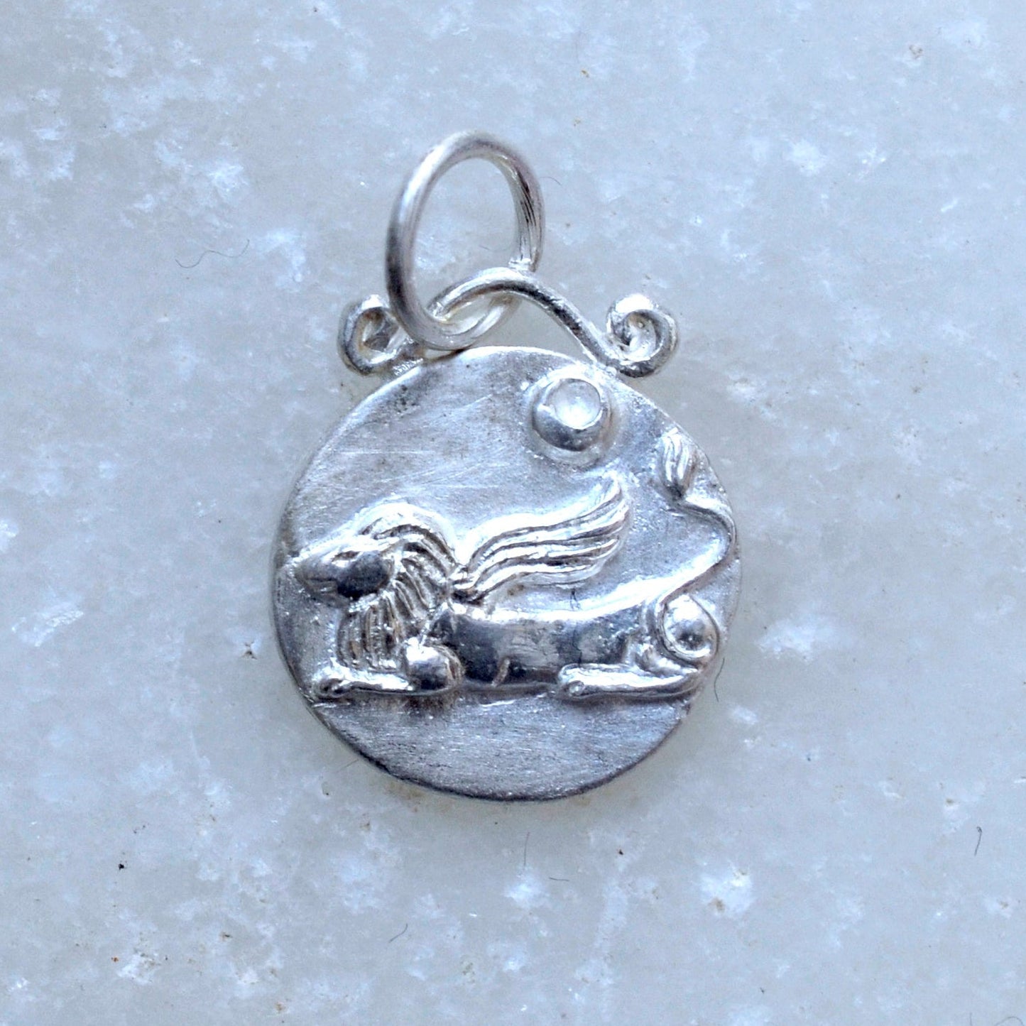 Leo zodiac pendant in silver on marble