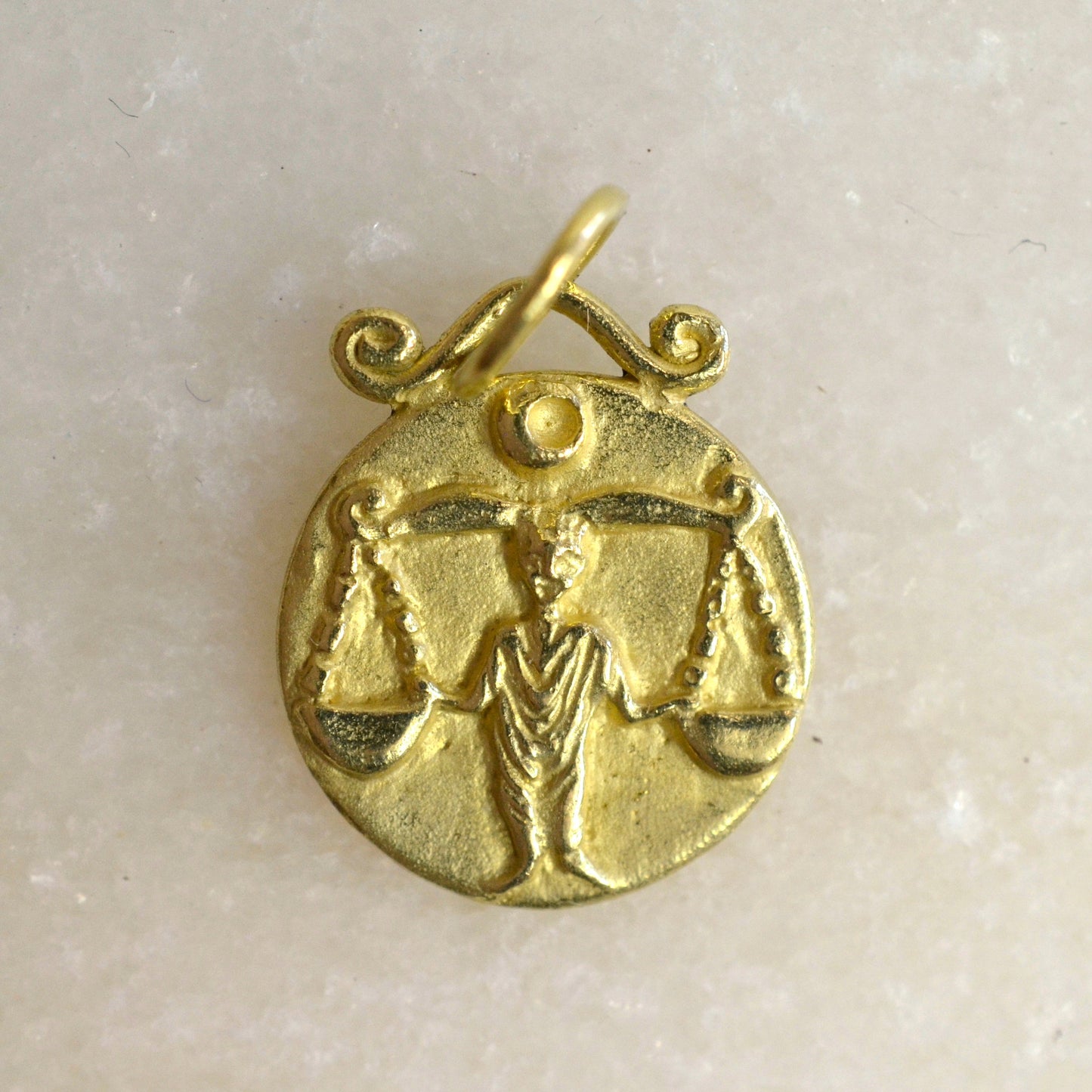 Libra zodiac pendant in 18 karat gold on marble