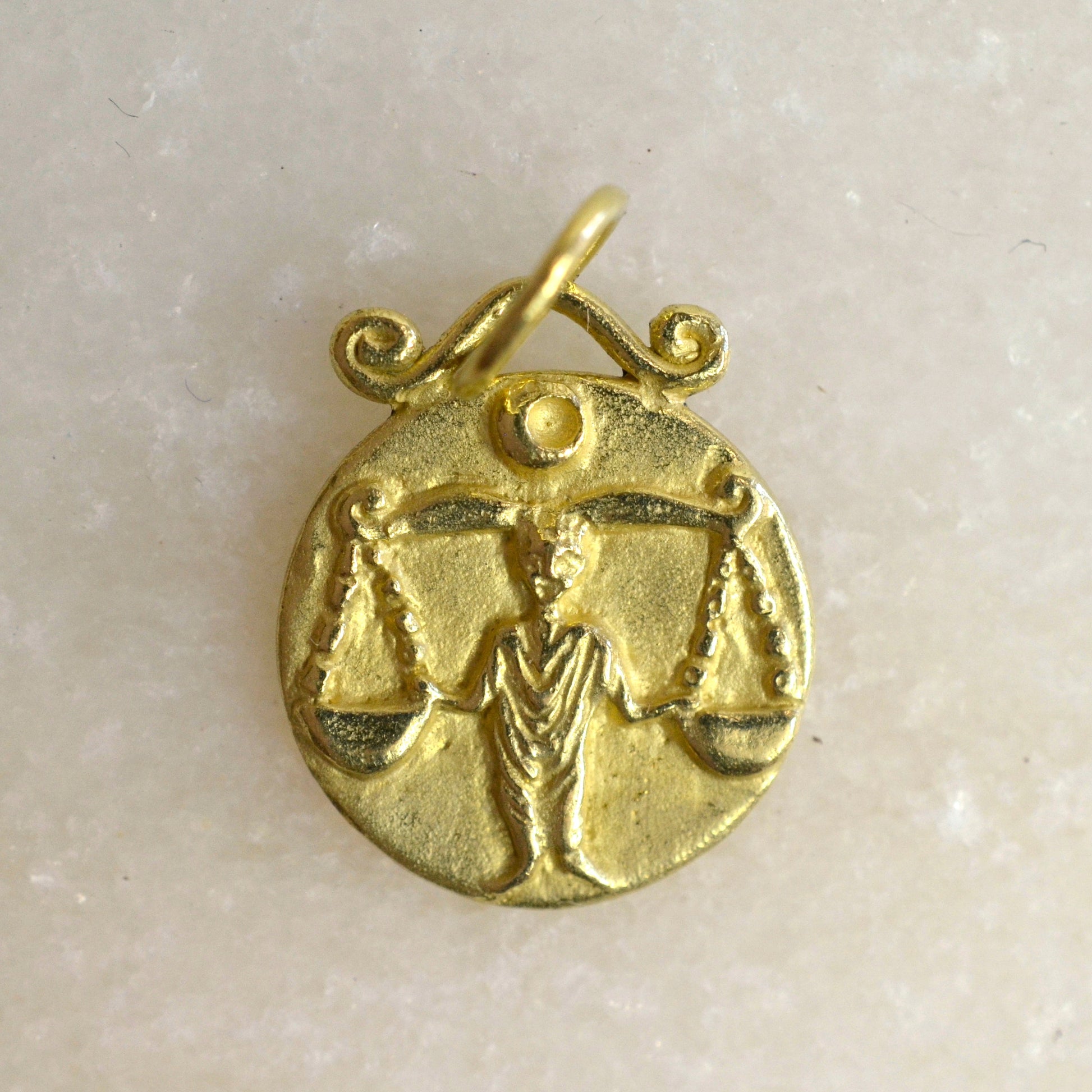Libra zodiac pendant in 18 karat gold on marble