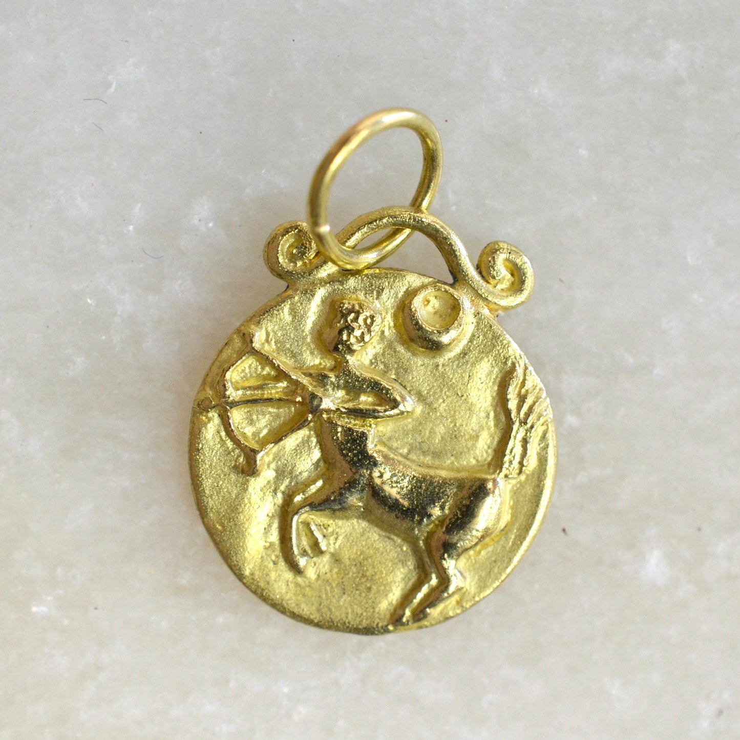 Sagittarius zodiac pendant in 18 karat gold on marble