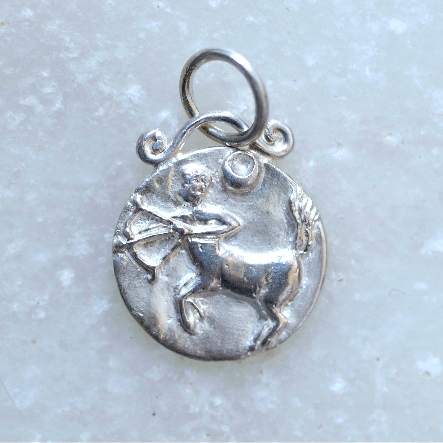 Sagittarius zodiac pendant in silver on marble