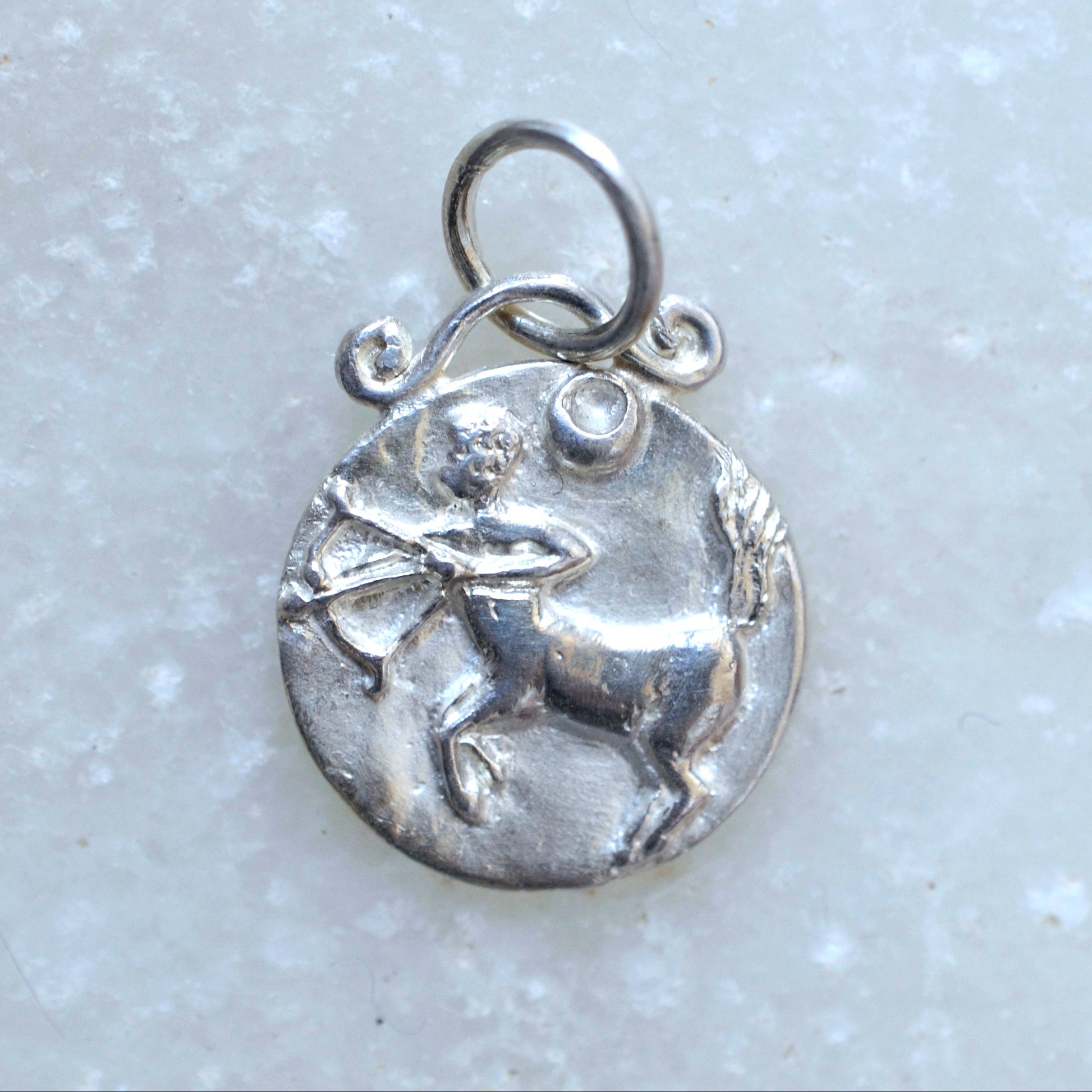Sagittarius zodiac pendant in silver on marble