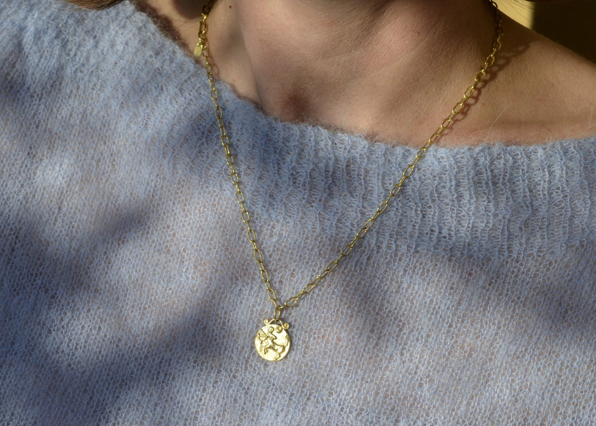 Sagittarius zodiac pendant in 18 karat gold worn on a handmade chain