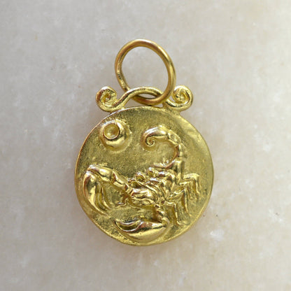 Scorpio zodiac pendant in 18 karat gold on marble