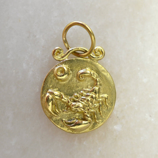 Scorpio zodiac pendant in 18 karat gold on marble
