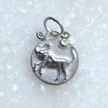 Taurus zodiac pendant in silver on marble