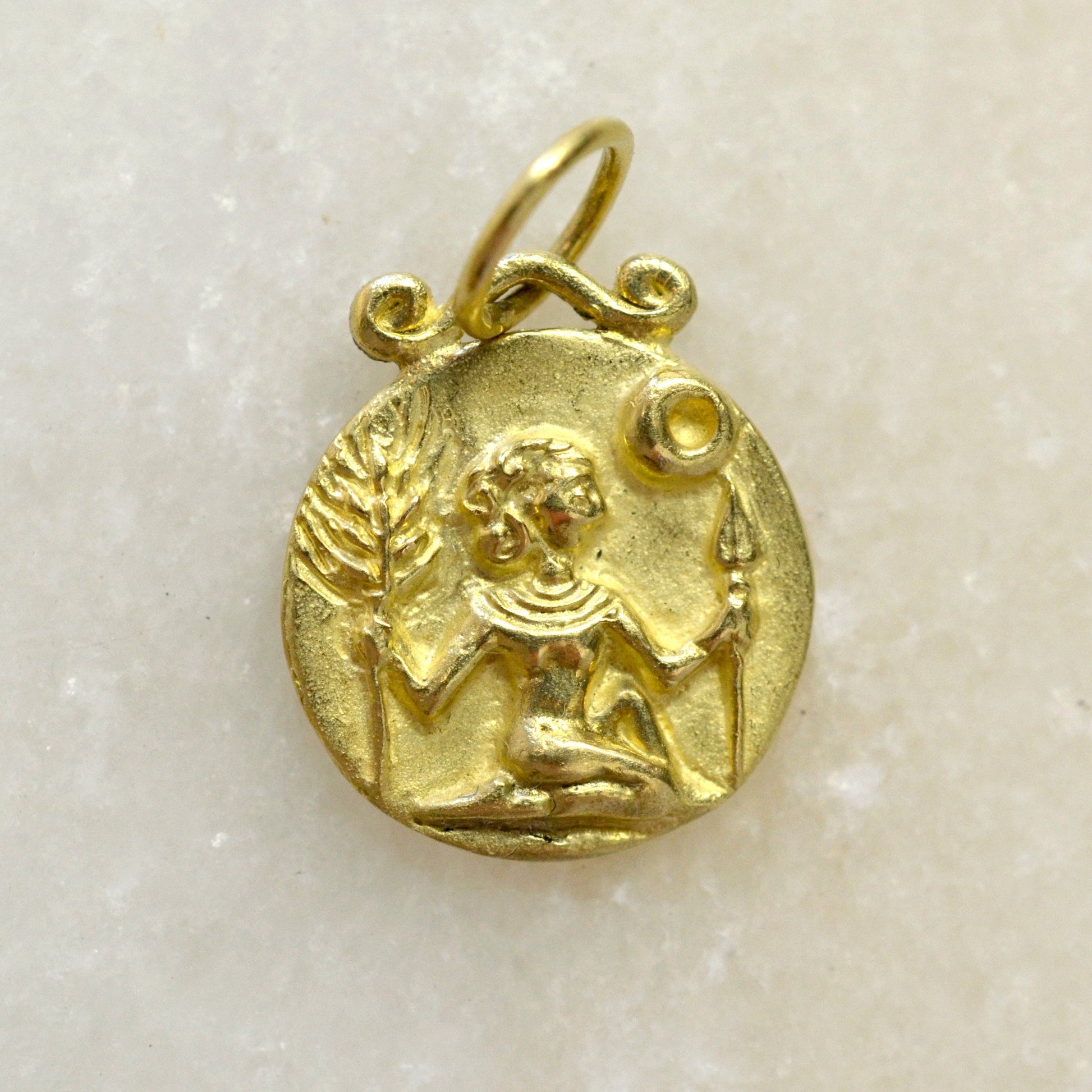 Virgo zodiac pendant in 18 karat gold on marble