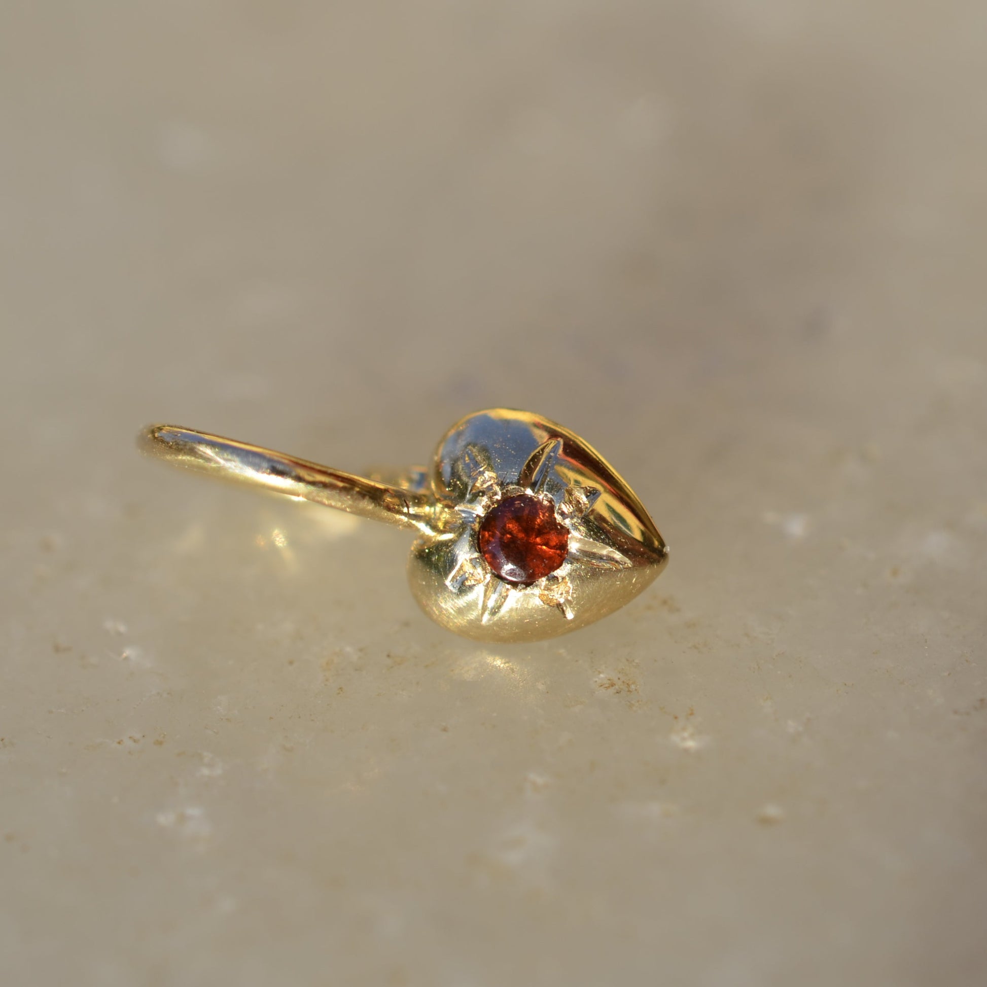 Heart shaped pendant in 18 karat gold with a garnet