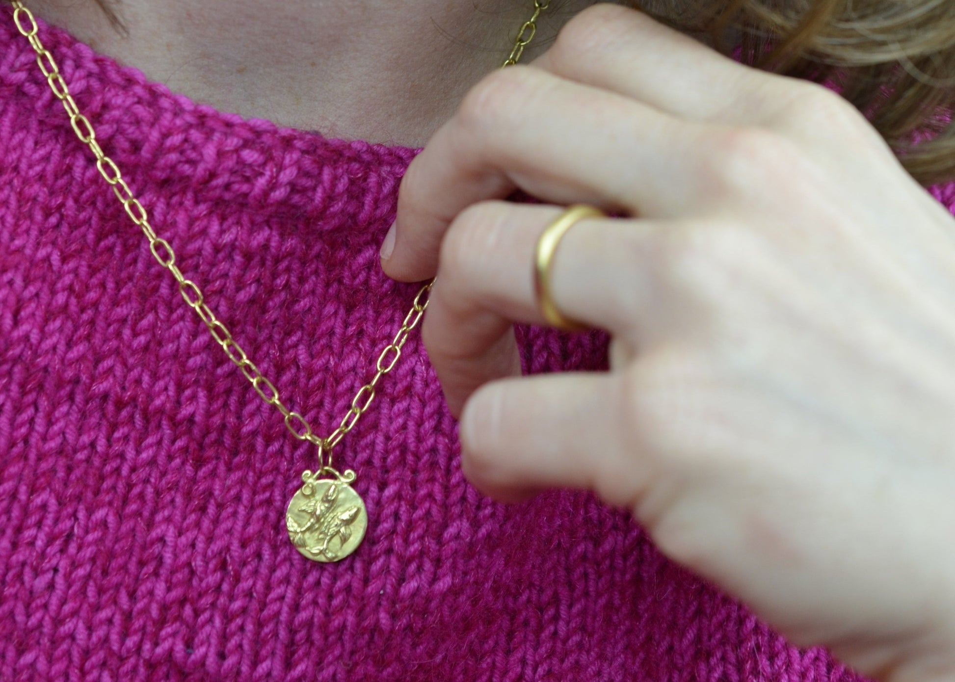 pisces zodiac pendant in 18 karat gold worn on a handmade chain 
