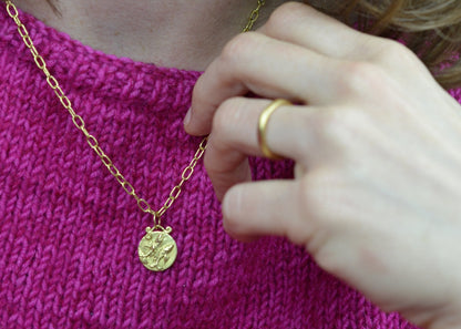 pisces zodiac pendant in 18 karat gold worn on a handmade chain 