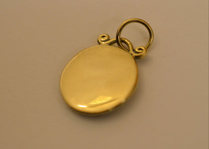 backside of zodiac pendants in 18 karat on dark white surface