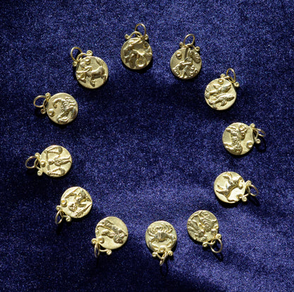 12 zodiac pendants in 18 karat gold on blue velvet